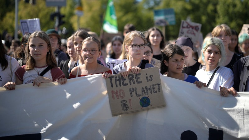 Globaler Klimastreik 2023 in Berlin: Schüler halten ein Pappschild mit der Aufschrift "There is no planet B"