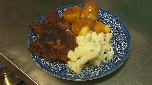 Kotelett mit Kartoffeln und Bratensauce und Blumenkohl