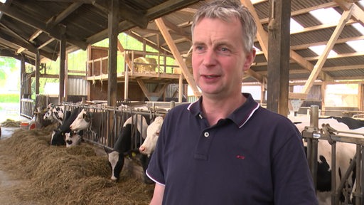 Der Landwirt Carsten Schnackenberg steht im Kuhstall auf seinem Hof.