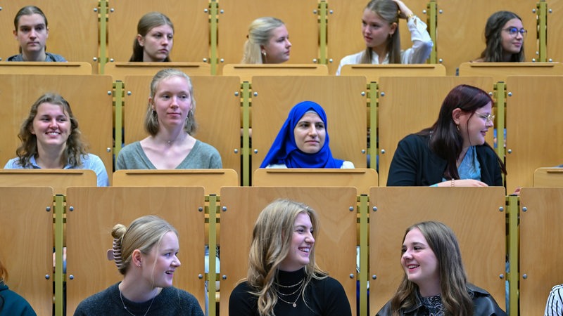 Junge Studierende sitzen in einem Hörsaal.