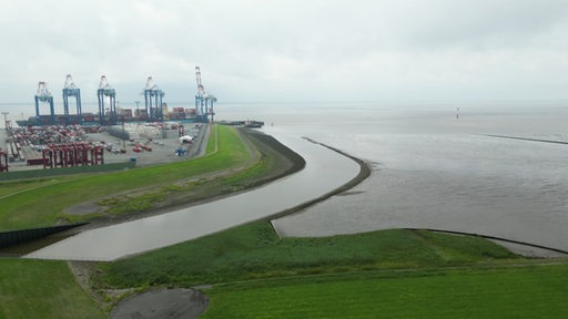 Der Ausblick in Bremerhaven Weddewarden auf das Meer, weit entfernt fährt ein Schiff