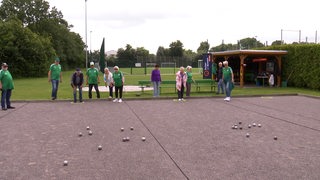 Menschen spielen auf einem Platz in Bremerhaven-Wulsdorf Boule.