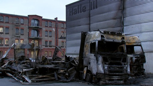 Ein ausgebrannter LKW vor Halle drei.