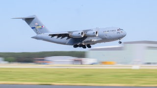 Ein Militärflugzeug landet an einem Flughafen.