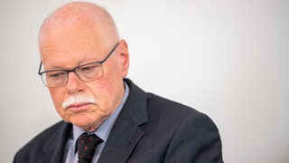 Ulrich Mäurer, Bremer Innensenator, schaut in Richtung Boden