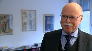 Ulrich Mäurer steht in einem Büro in Bremen