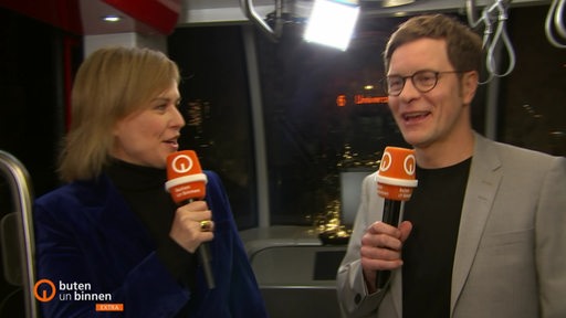 Moderatoren Kirsten Rademacher und Felix Krömer in einer Straßenbahn.