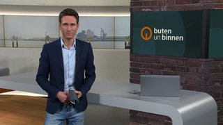 Moderator János Kereszti im Studio von buten un binnen.