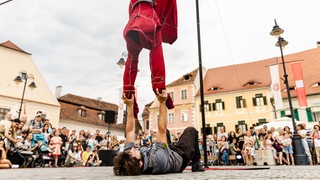 Artisten von "manoAmano" bei einer Straßenaufführung vor Publikum