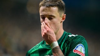 Werder-Kapitän Marco Friedl fasst sich ans Gesicht