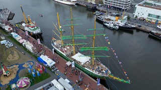 Blick von oben auf einen Hafen mit zahlreichen Schiffen.