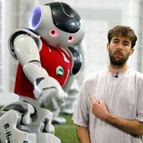 Ein junger Mann steht vor einem Roboter