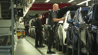 Menschen arbeiten im Bremer Mercedes-Werk am Band.