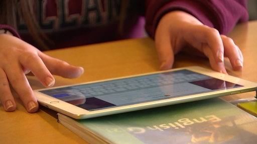 Ein Schüler lernt am Ipad in der Schule. 