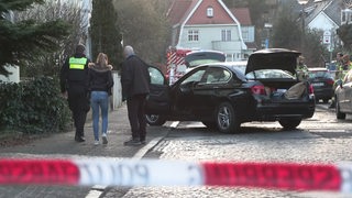 Ein Auto mit Einschussloch steht auf einer Straße.