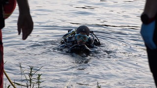 Ein Taucher taucht aus dem Wasser auf