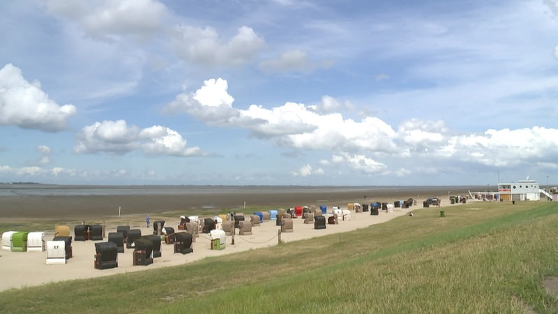 Der Ferienort Dangast. Strand, Meer, Strandkörbe unter blauem Himmel.