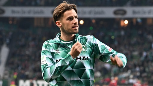 Fußballprofi Olivier Deman gestikuliert im Trainingsdress von Werder Bremen