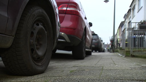 Parkende Autos auf einem Bordstein.