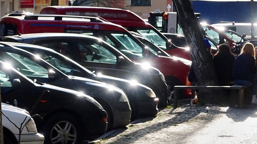 Autos parken dicht an dicht am Straßenrand.