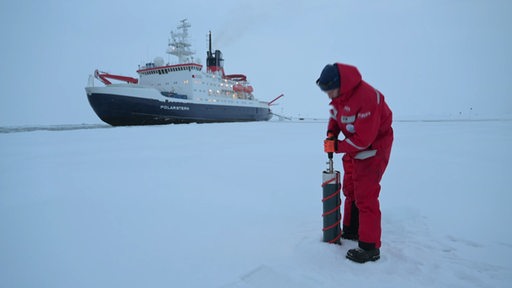 Die Polarstern, vor ihr der schneebedeckte Boden, auf dem eine Person steht.