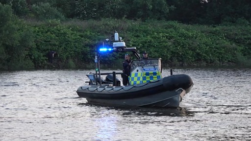 Ein Schlauchboot der Polizei während eines Einsatzes auf einem Fluss.