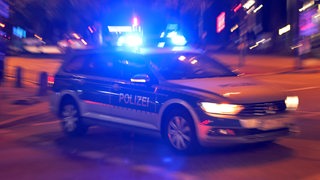 Ein Streifenwagen fährt mit Blaulicht zu einem Einsatz.