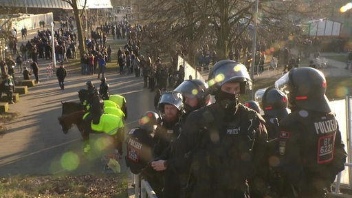 Polizeibeamte stehen vor einer Menschenmenge