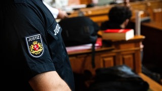 Ein Justizbeamter aus Bremen steht im Gerichtssaal.