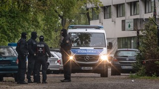 Vermummte Einsatzkräfte stehen an der Straße vor der Moschee der Al-Mustafa-Gemeinschaft in Bremen.