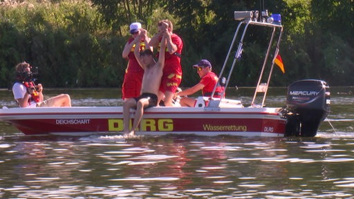 Wasserretter ziehen einen Menschen aus dem Wasser