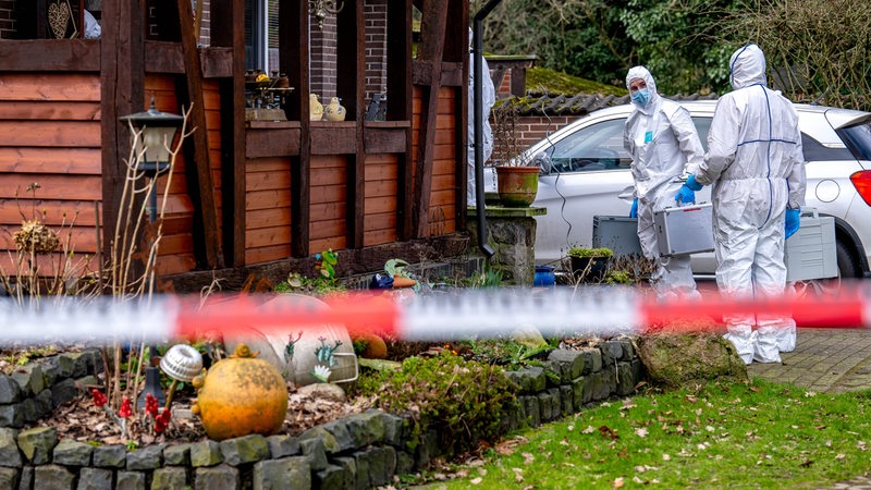 Beamte der Spurensicherung gehen zu einem Einfamilienhaus in der Gemeinde Scheeßel. 