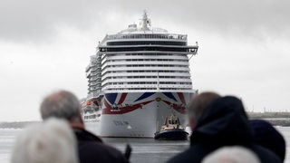 Ein Kreuzfahrtschiff liegt in einem Hafen.