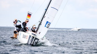 Das Bundesliga-Boot des Hemelinger Wassersport-Vereins liegt beim Spieltag in Travemünde schräg im Wind.