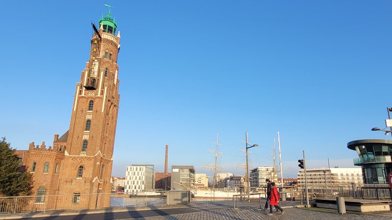 Blick auf einen Leuchtturm aus roten Backsteinen mit grüner Kuppel.