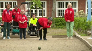 Die drei Bremerinnen trainieren Boccia auf dem Spielfeld. 