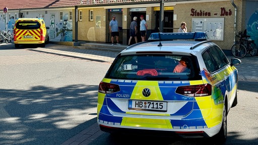 Fahrzeuge von Polizei und Rettungswagen stehen vor dem Stadionbad.