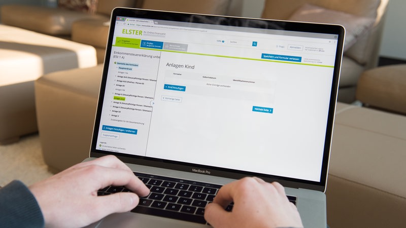 Hände an einem Computer füllen einen Antrag auf der Steuerplattform Elster aus