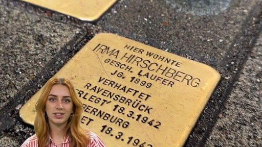 Bianca Marstaller im Studio vor einem Bild mit Bremer Stolpersteinen