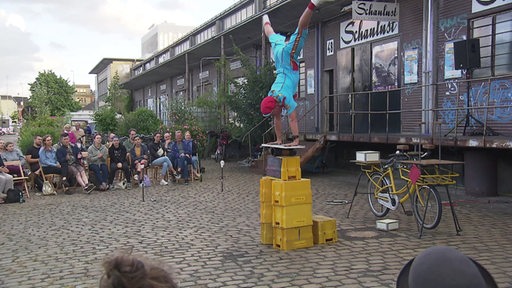 Ein Artist turnt im Straßentheater bei der Schaulust in Bremen. 