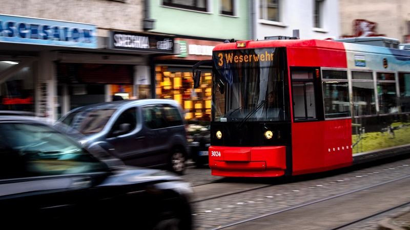 Eine Straßenbahn fährt zwischen Autos durch Bremen.