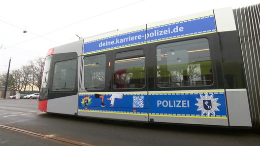 Eine Straßenbahn mit Polizei Aufdruck.  