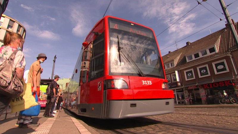 Eine Straßenbahn der BSAG hält an einer Haltestelle.