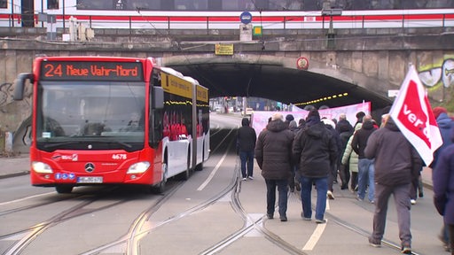 Streikende passieren einen Bus vor dem Bahnhofstunnel