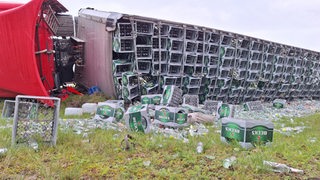 Ein umgekippter Lkw liegt neben einer Autobahn.