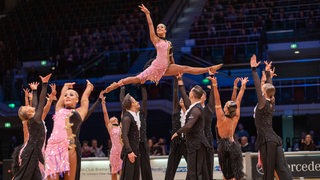 Die Lateinformation des Bremer Grün-Gold-Clubs bei einer Pose der Choreografie "Emozioni 2022" in der Bremer Stadthalle.