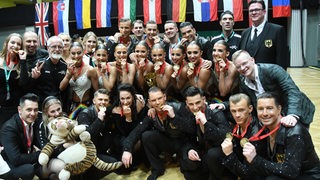 Die Lateinformation des Bremer Grün-Gold-Clubs posiert im Gruppenbild mit ihren Goldmedaillen bei der WM in Wien.