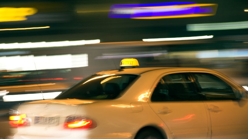 Ein Taxi fährt auf einer Straße.