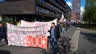 Menschen halten Transparente und Banner hoch