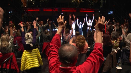 Ensamble und Zuschauer interagieren während einer Probe des Musicals "Cabaret" 